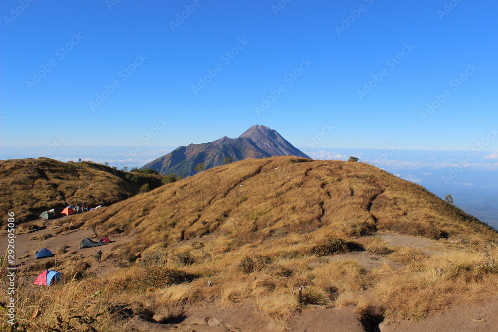 beautiful blue skies and brownish grasslands on a clear morning while climbing Mount Merbabu Magelang, Central Java, Indonesia