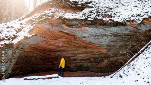 Wallpaper Mural Man with yellow jacket standing in the cave in Gauja National Park. Torontodigital.ca