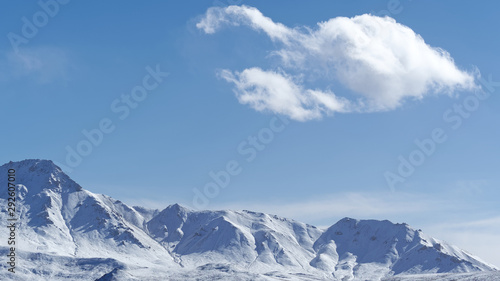 White clouds floating over snow mountains with blue sky background, beautiful landscape of China southwest.