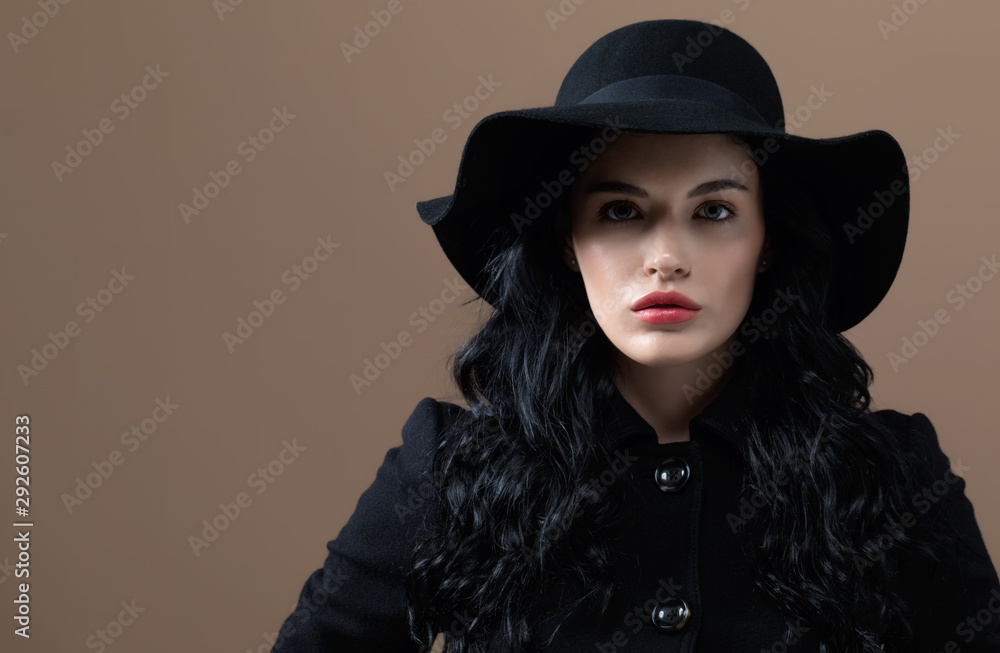 Beautiful young woman in a fashionable coat on a brown background Beautiful young woman in a fashionable coat on a brown background