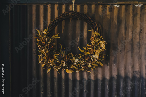 Dry flower wreath hanging on tin wall