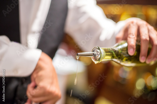 chef pouring olive oil in to the pan for make a sauce