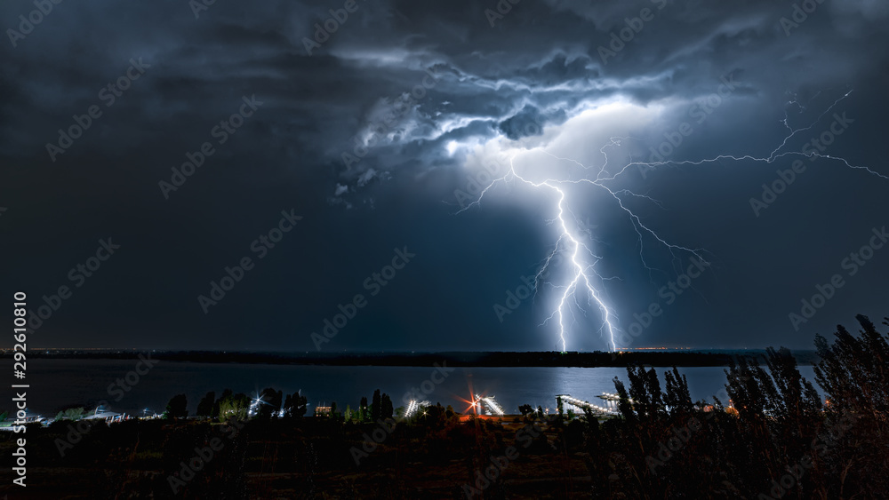 Lightning strike in the night sky above the river Lightning strike in the night sky above the river