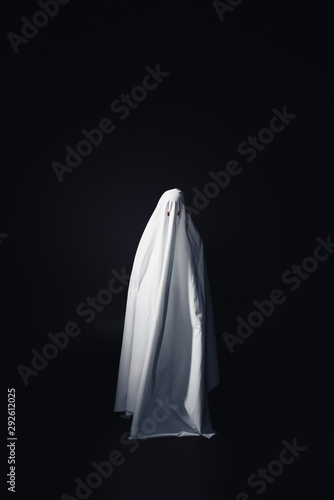horrible ghost in white bedsheet isolated on black with copy space photo