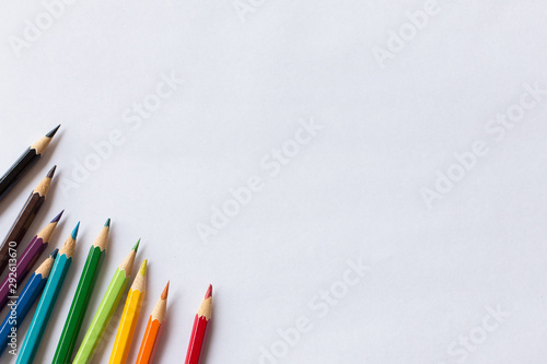 colorful colored pencil and white paper  on wooden background