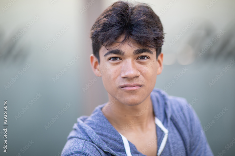 Portrait of a handsome cocky young man next to the blurred background