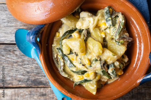 Mexican poblano rajas with potatoes and sour cream in clay cazuela photo