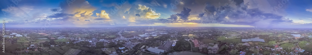Aerial view panorama 360 degree above green rice fields, village, and reservoir with cloudy sky background, Krajub reservoir in Ban Pong, Ratchaburi, Thailand.