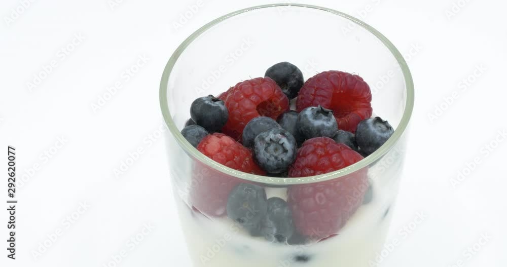 Yogurt with blueberry and raspberry rotating on white background. Yogurt with blueberry and raspberry rotating on white background.