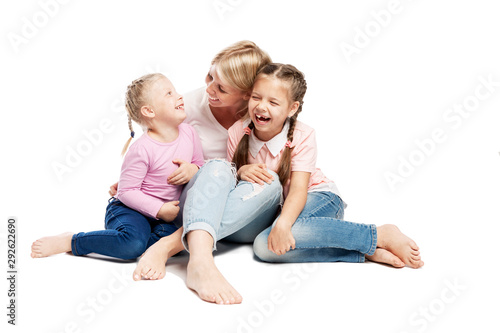 Mom and daughters are sitting and laughing. Love and tenderness. Isolated over white background.