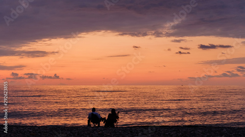 Couple relaxing and looking at sunset