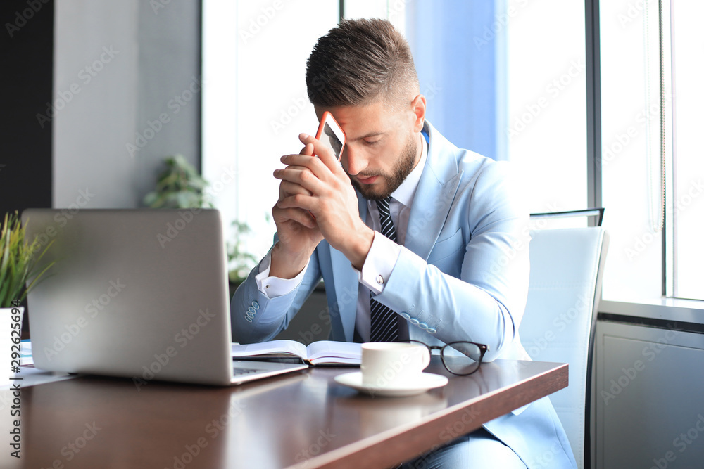 Modern businessman thinking about something while sitting in the office Modern businessman thinking about something while sitting in the office