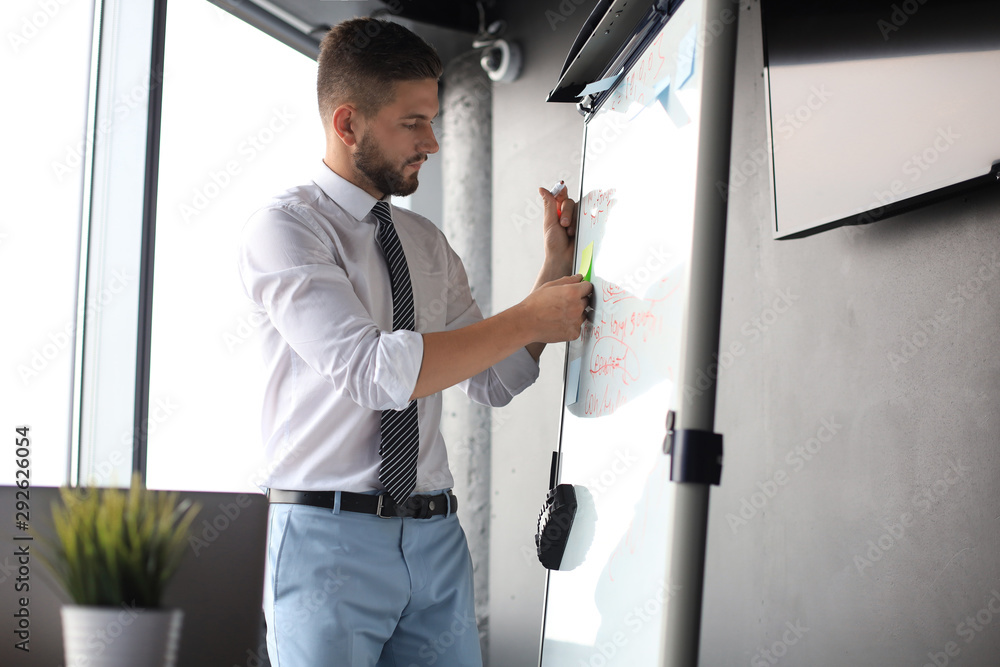 Modern businessman is using flipchart in the office Modern businessman is using flipchart in the office