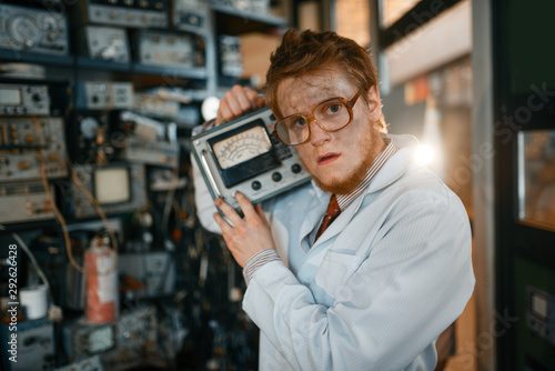 Scientist in glasses holds electrical device