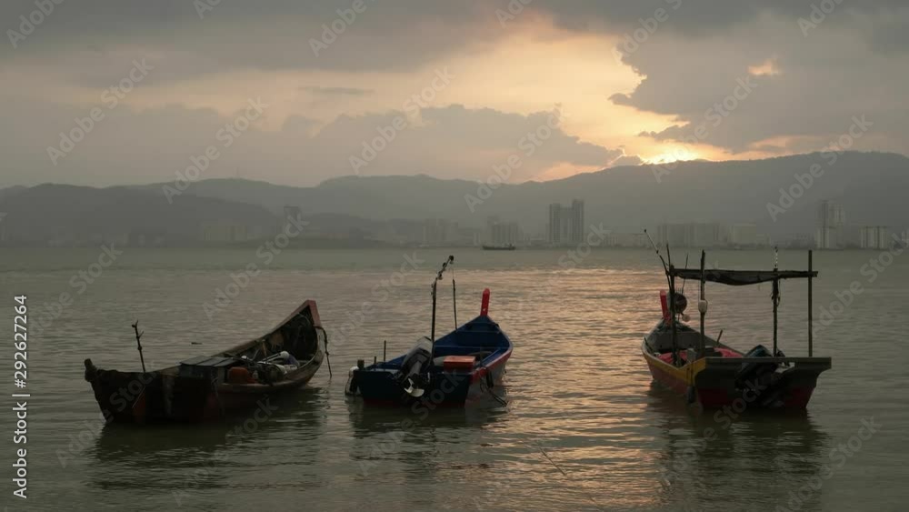Three traditional wooden fishing boat stay calm on the sea during evening hour after rain. Three traditional wooden fishing boat stay calm on the sea during evening hour after rain.