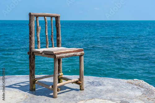 Wooden chair in empty cafe next to sea water in tropical beach . Island Koh Phangan  Thailand