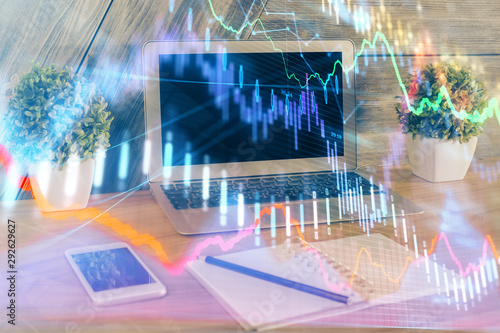 Financial graph colorful drawing and table with computer on background. Double exposure. Concept of international markets. © peshkova