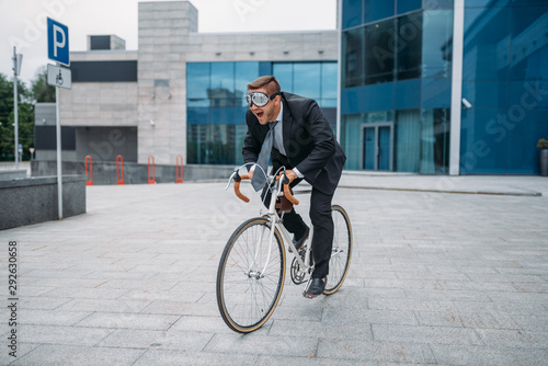 One businessman in funny glasses poses on bicycle