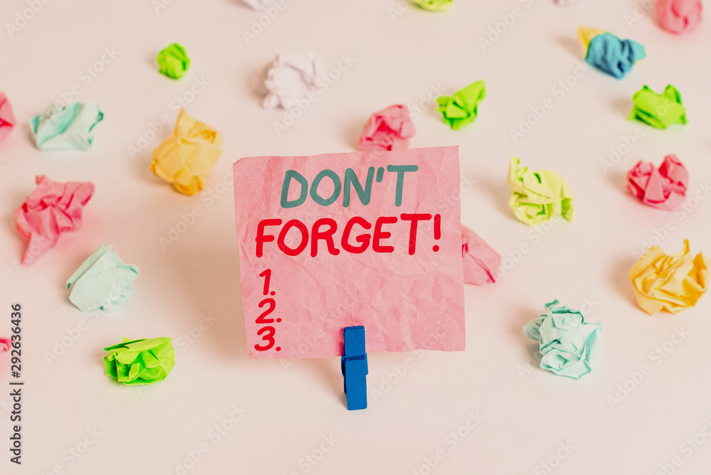 Conceptual hand writing showing Don T Forget. Concept meaning used to remind someone about important fact or detail Colored crumpled paper empty reminder white floor clothespin