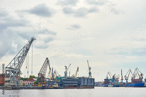 working crane bridge in shipyard and cargo ships in a port