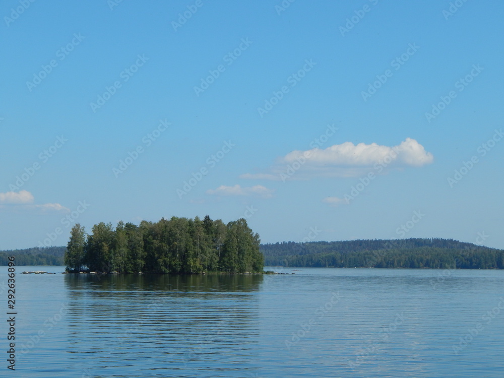 Scenic view of a lake with a small island on a sunny summer day