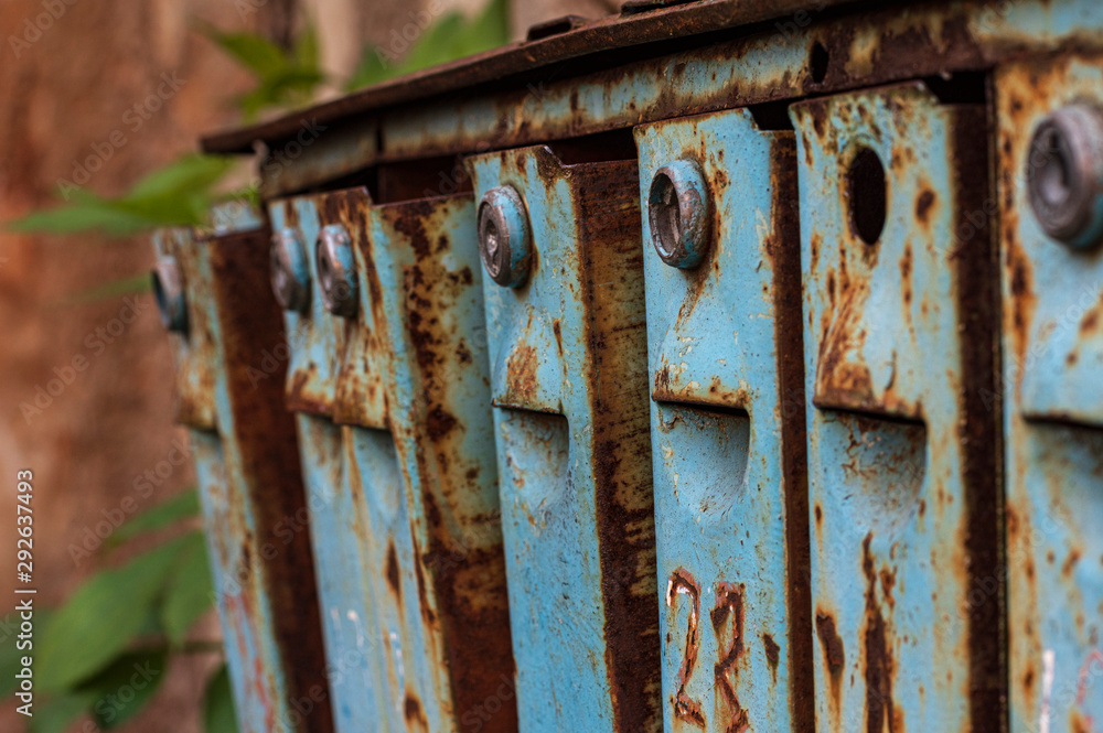 Old blue rust-coated iron mailboxes Old blue rust-coated iron mailboxes
