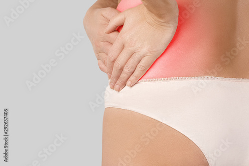 female body with a focus of acute pain in the left side, the woman holds her hands touching the sore spot highlighted in red