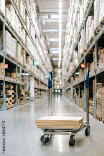 Trolley with packing box in warehouse inventory storage factory. Logistic transportation storehouse concept.