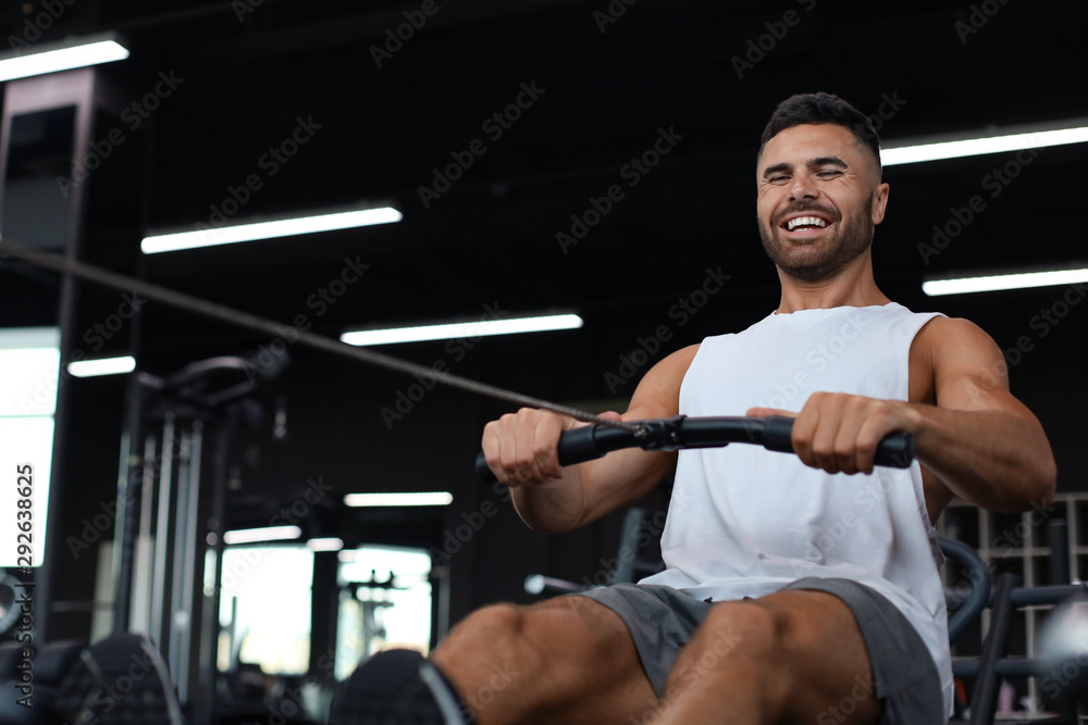 Fit and muscular man using rowing machine at gym. Fit and muscular man using rowing machine at gym.