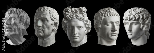 Five gypsum copy of ancient statue heads isolated on a black background. Plaster sculpture mans faces. photo