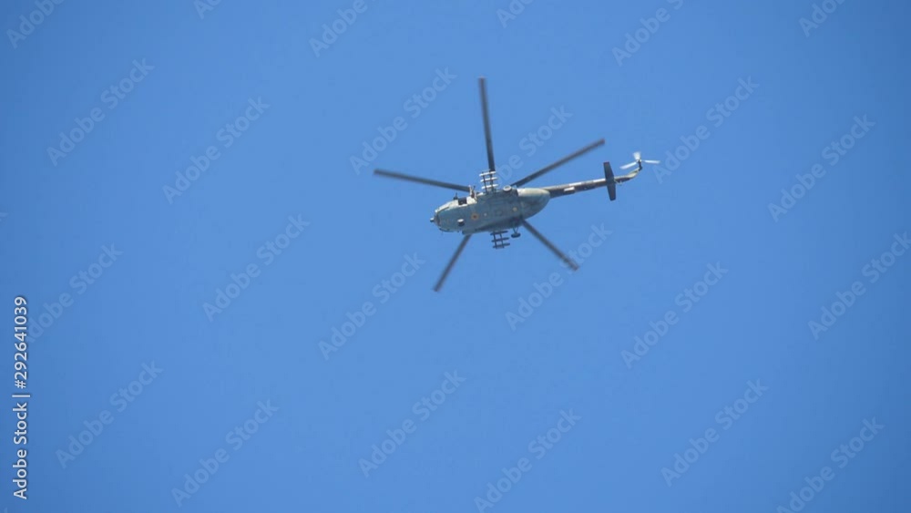 Military skydiver jumping out of a chopper with an opening white parachute Military skydiver jumping out of a chopper with an opening white parachute