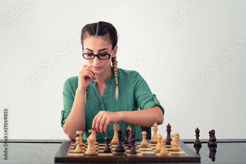 Young  brunette woman playing chess and  find winning strategy