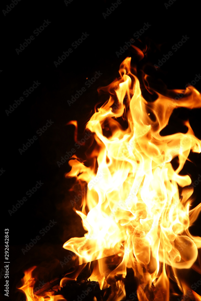 Tongues of flame of fire of orange-yellow color from burning firewood Tongues of flame of fire of orange-yellow color from burning firewood