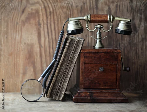 Obraz Stary telefon i retro książka na drewnie