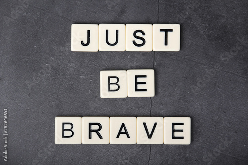 A motivational quote Just be brave formed with tile letters