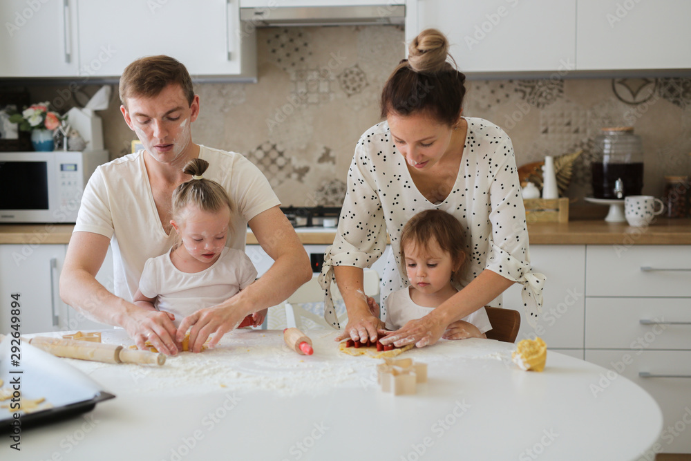 Caucasian family with two kids cooking together Caucasian family with two kids cooking together