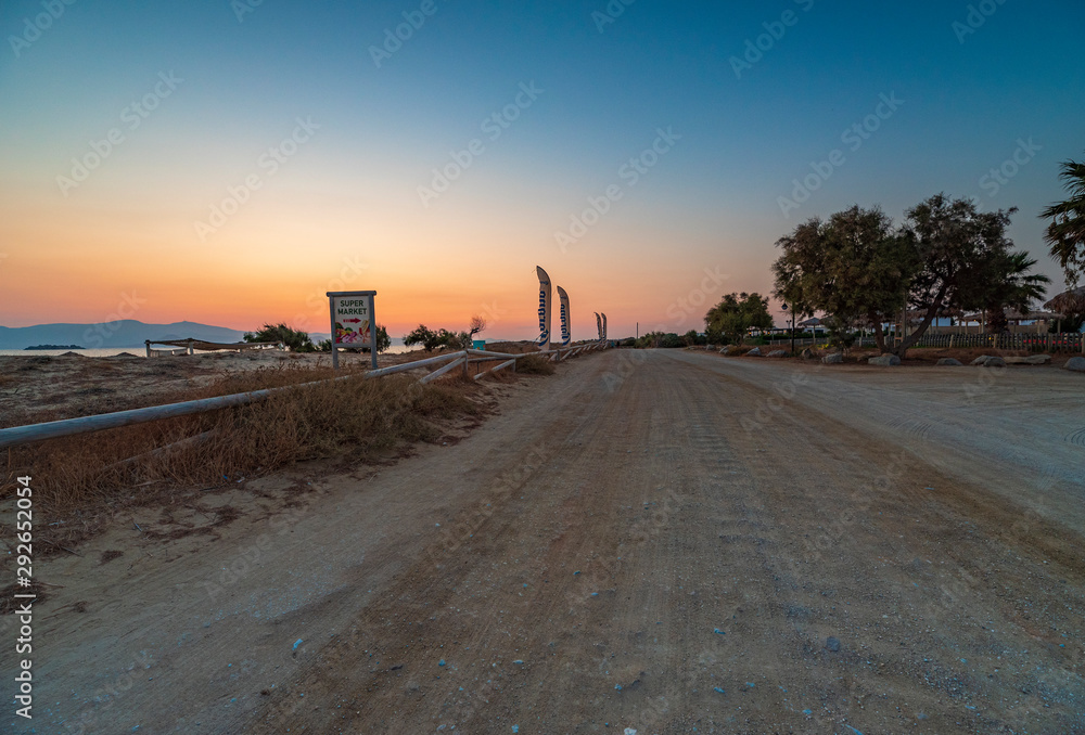 Vista della strada sterrata che costeggia la spiaggia di Plaka al crepuscolo, isola di Naxos GR	