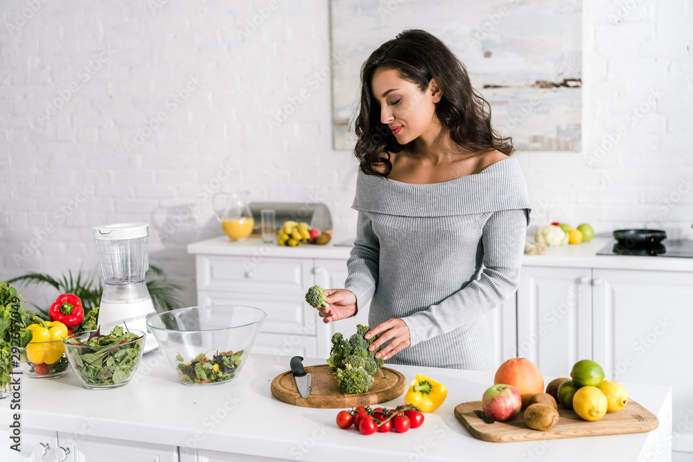 young attractive woman preparing salad at home