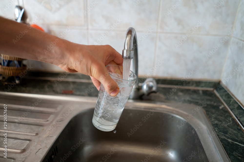hand holding a glass and pouring pure water in it to drink. hand holding a glass and pouring pure water in it to drink.