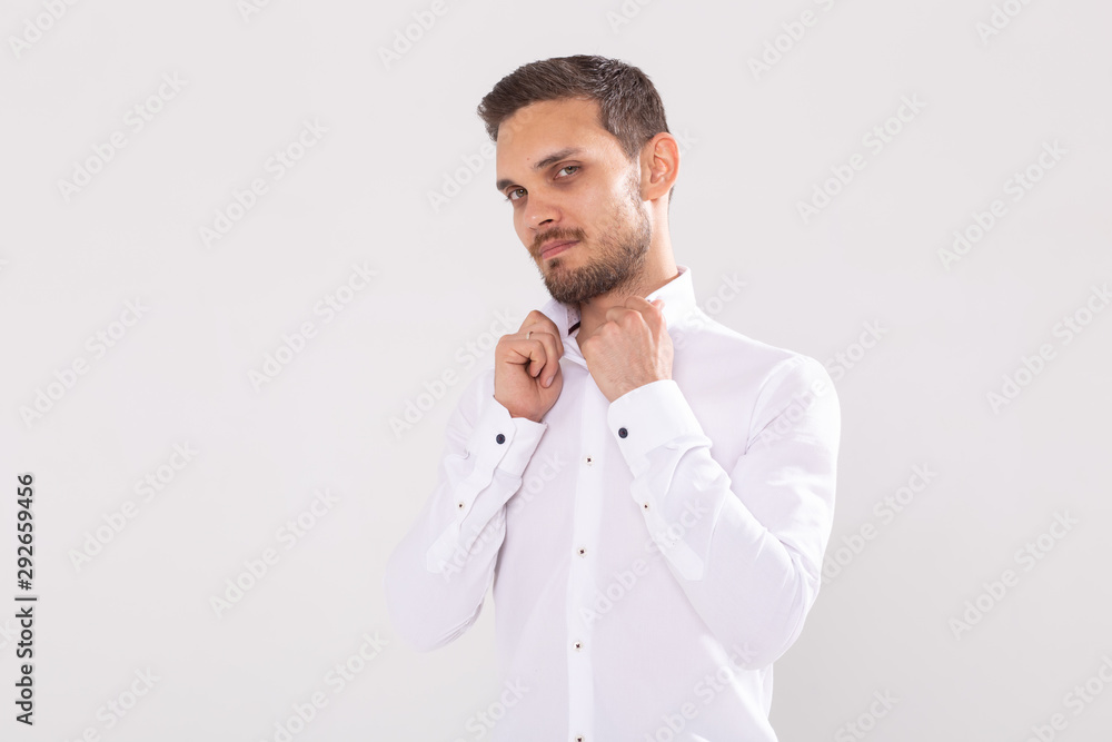 Portrait of handsome happy young man in casual shirt standing against white background with copy space Portrait of handsome happy young man in casual shirt standing against white background with copy space