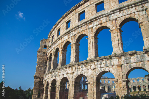 Close up picture of the colosseum in Pula Croatia with blue sky and small windows view from there, local and famous landmark in city with big history, wallpaper for greeting card from vacation