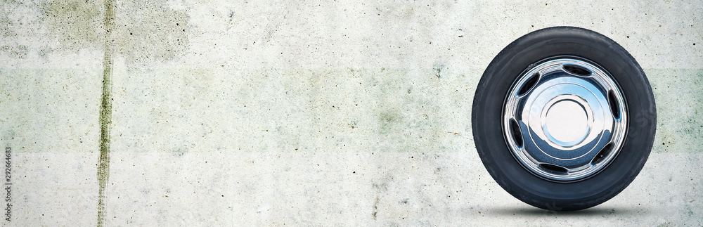 Fototapeta premium Car wheel on gray concrete background. Copy space. Transport. Spare parts.