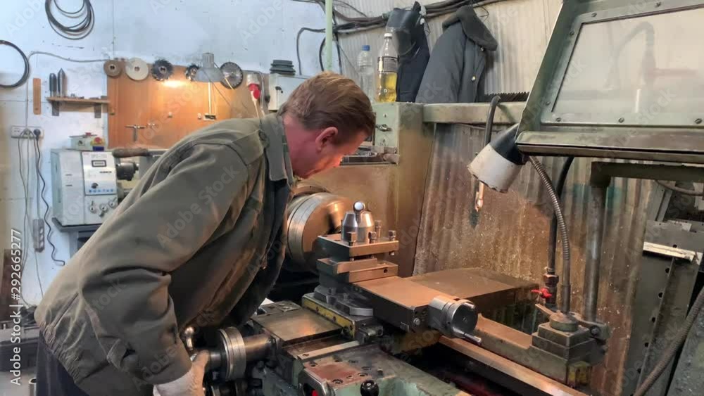 Turner behind a turning and milling machine. Product turning according to the drawing. Grinding roller. Industrial factory.working turner_2 Turner behind a turning and milling machine. Product turning according to the drawing. Grinding roller. Industrial factory.working turner_2