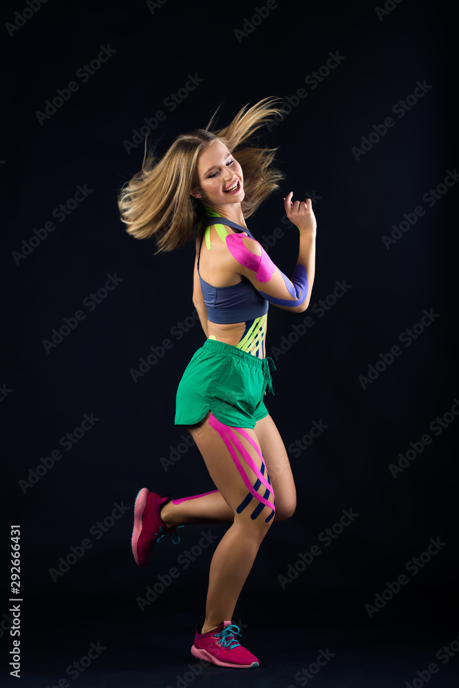 Beautiful atlette woman dancing in kinesio tapes Beautiful atlette woman dancing in kinesio tapes