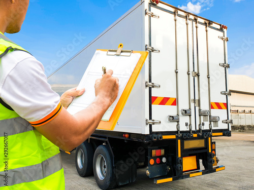 Worker hand holding clipboard  inspecting checklist load control the shipment with the truck container, Freight industry logistics and warehouse, Cargo courier shipment transport.   © Siwakorn1933