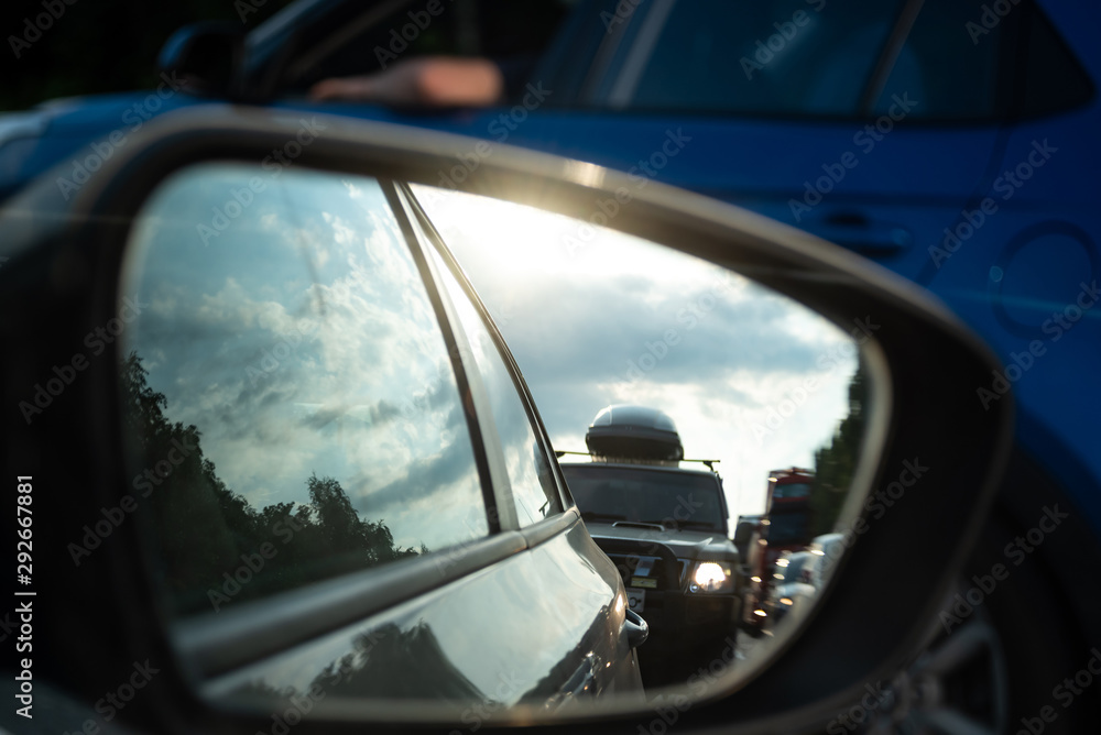 View in the side mirror of a car on the road. Traffic congestion, a large congestion of cars, difficult traffic. View in the side mirror of a car on the road. Traffic congestion, a large congestion of cars, difficult traffic.