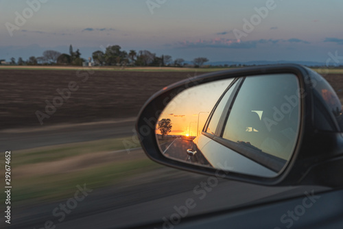 looking through a side mirrors with a sunset in it in australia