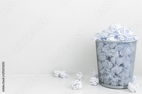 Crumpled paper throw into the gray trash on cement floor. Tossing paper scrap away bin. No idea.