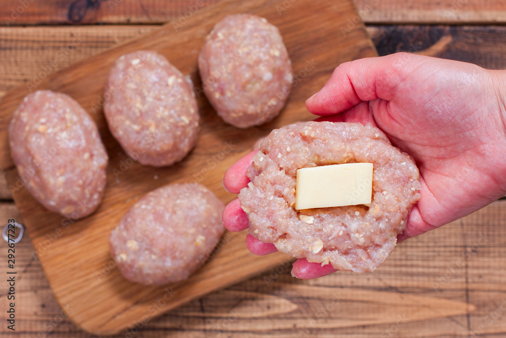 Step-by-step preparation of homemade turkey cutlets with cheese filling, step 2 - putting the cheese fillings into cutlets, top view, selective focus Step-by-step preparation of homemade turkey cutlets with cheese filling, step 2 - putting the cheese fillings into cutlets, top view, selective focus