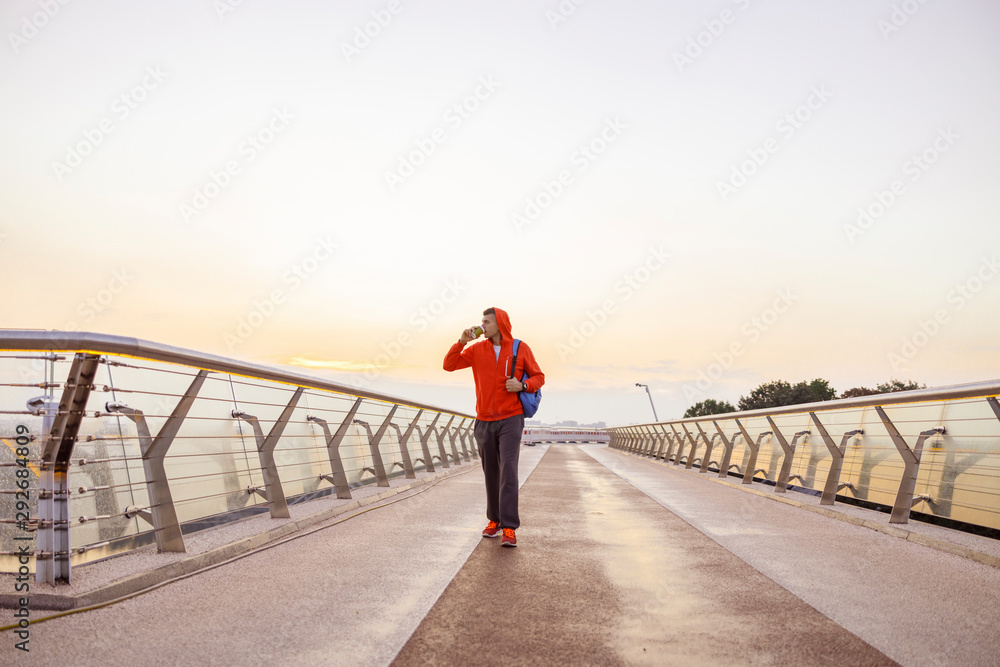 Attractive young man standing on a bridge